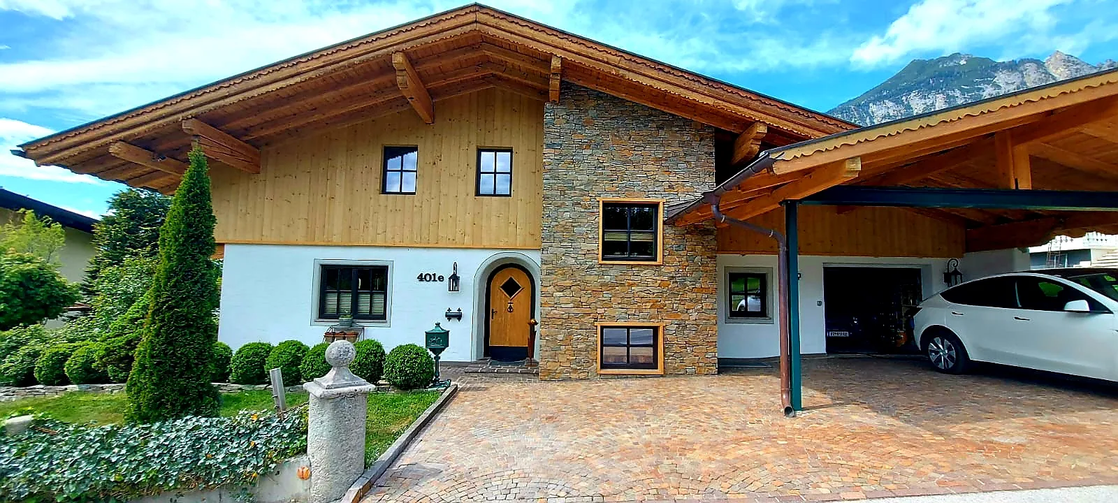 Wohnhaus mit Natursteinfassade und gepflasterter Zufahrt